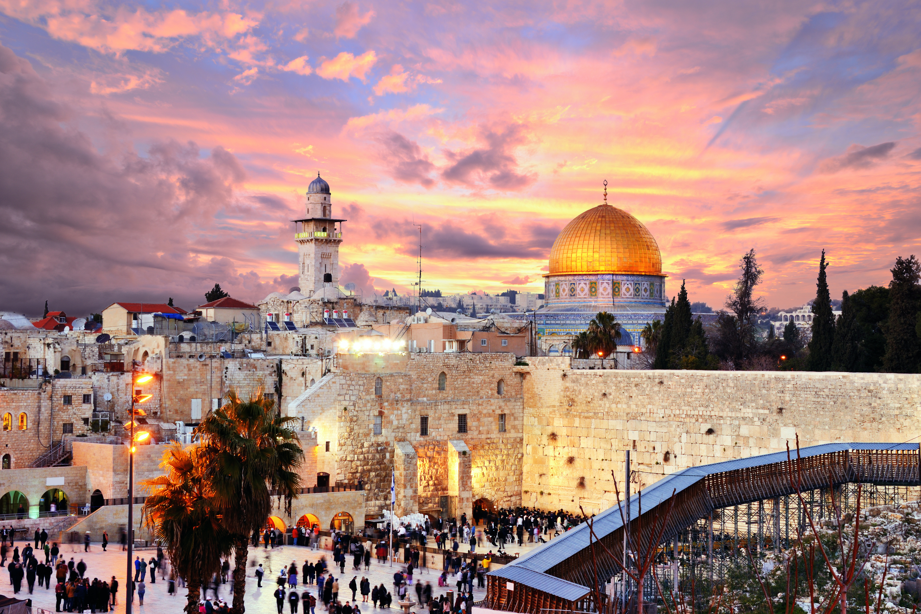Dome of the Rock in Jerusalem, Palestine, silhouetted against dramatic sunset sky with orange and purple clouds